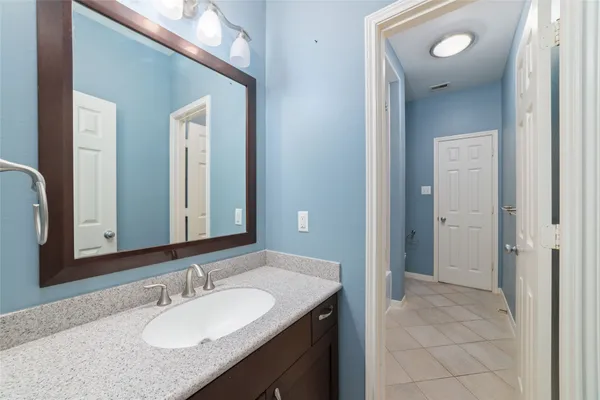a bathroom with a granite countertop sink and a mirror