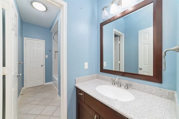 a bathroom with a granite countertop sink and a mirror
