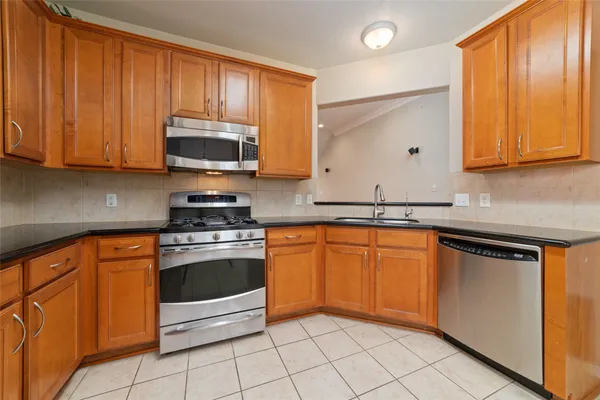 a kitchen with granite countertop stainless steel appliances a stove a sink and a microwave