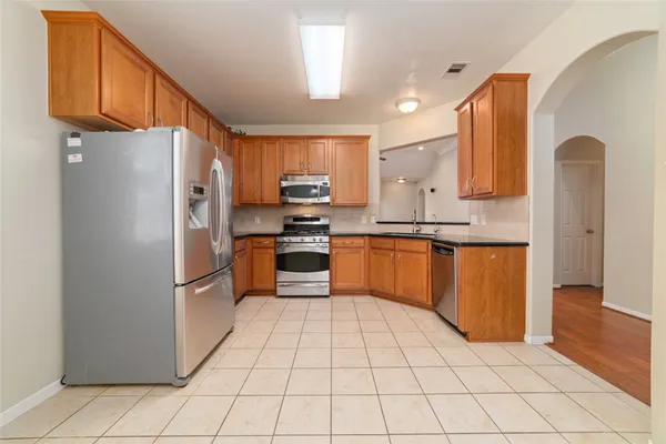 a kitchen with stainless steel appliances granite countertop a refrigerator sink and cabinets