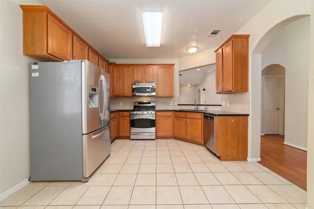 a kitchen with stainless steel appliances granite countertop a refrigerator sink and cabinets