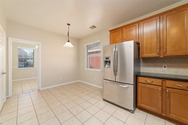 a kitchen with granite countertop a refrigerator a stove and cabinets