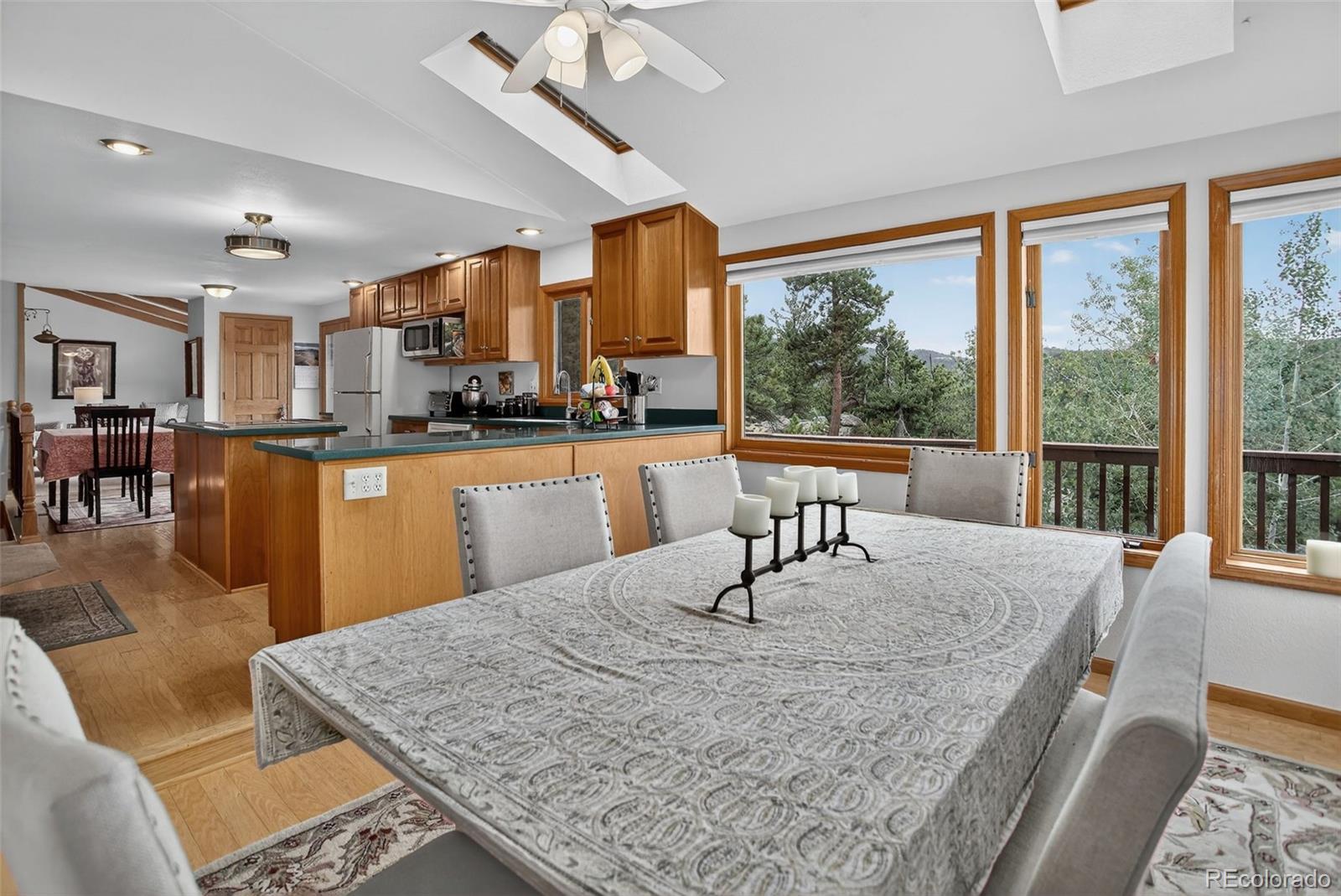 31911 Warrens Road Golden, CO 80403 - Photo 11 of 42 a view of a kitchen with kitchen island a large window cabinets a sink and stainless steel appliances