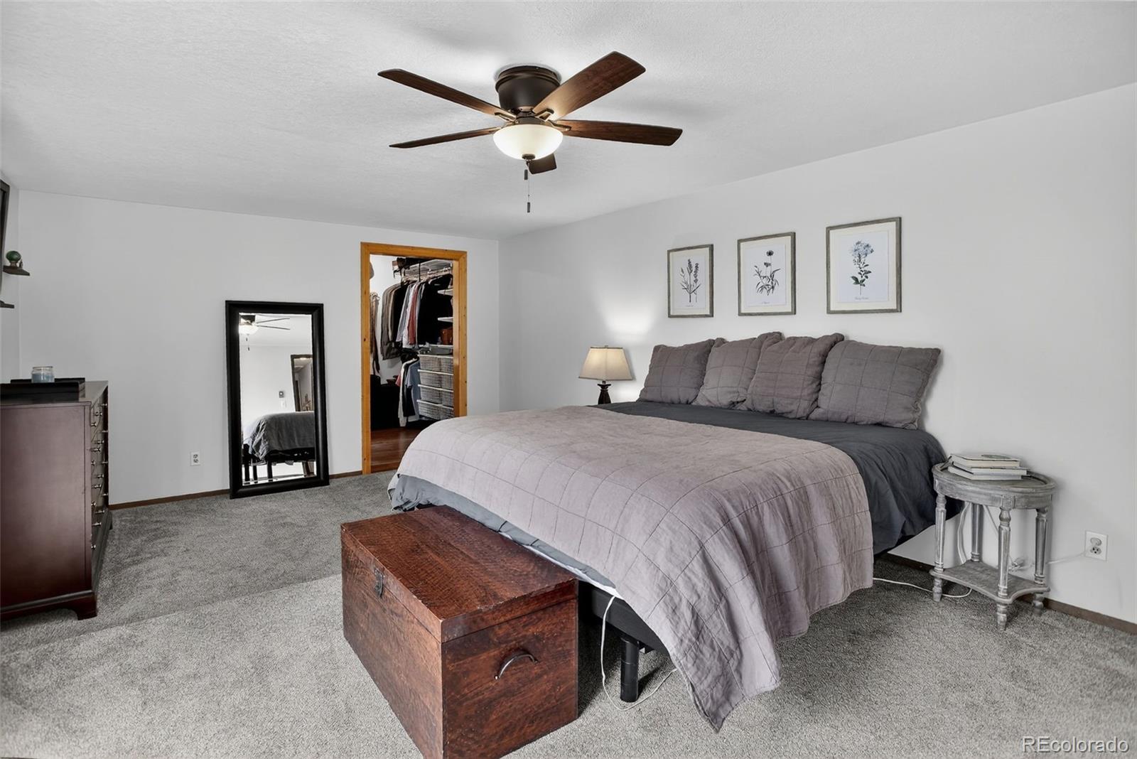 31911 Warrens Road Golden, CO 80403 - Photo 13 of 42 a spacious bedroom with a bed and a chandelier