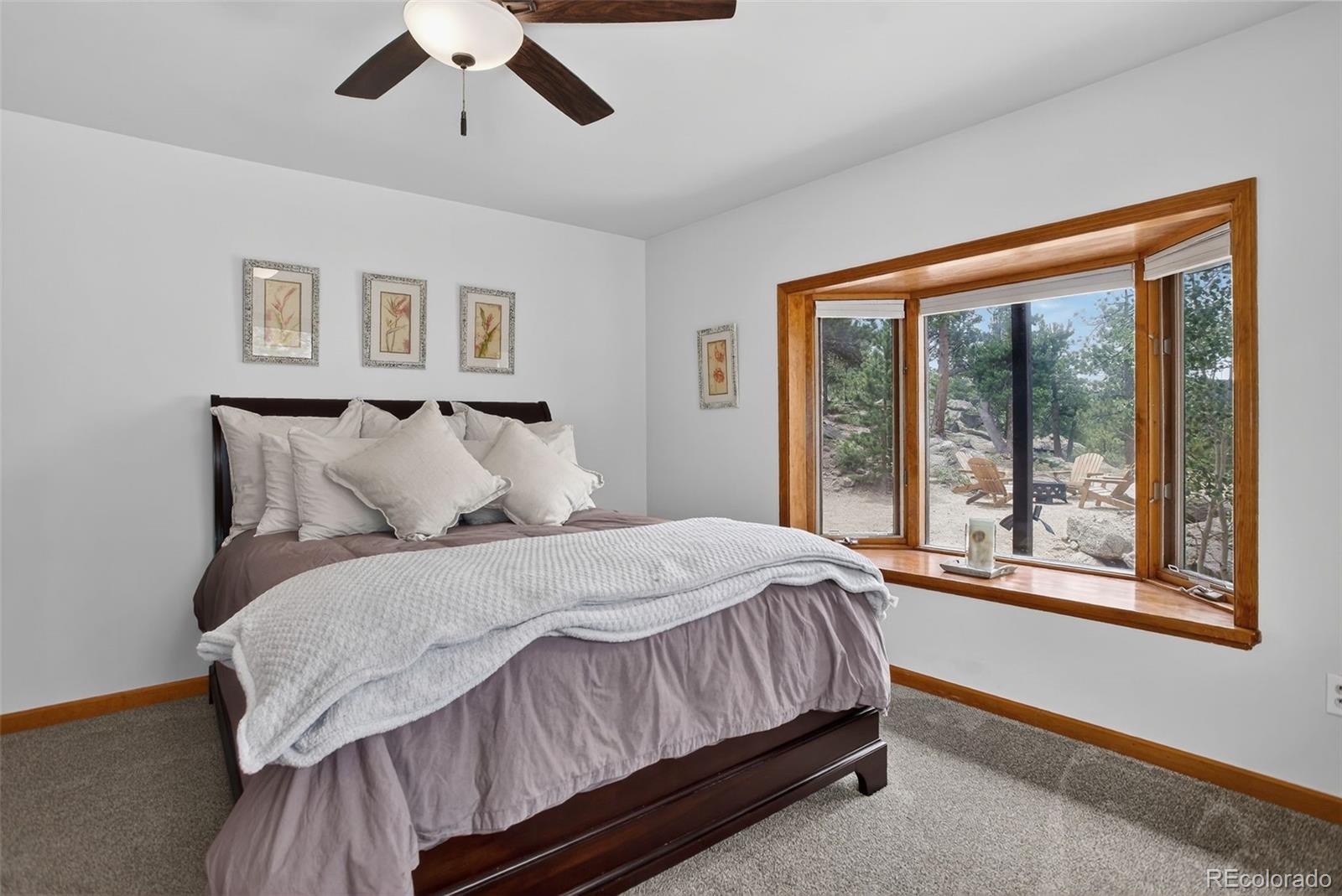31911 Warrens Road Golden, CO 80403 - Photo 24 of 42 a bedroom with a large bed and a large window