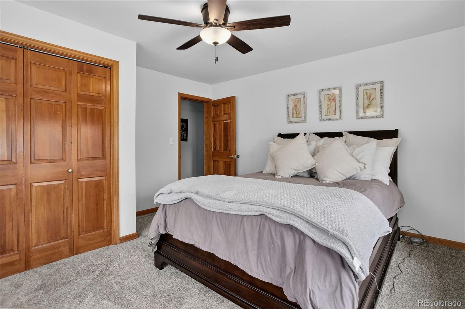 31911 Warrens Road Golden, CO 80403 - Photo 25 of 42 a bedroom with a bed and a chandelier