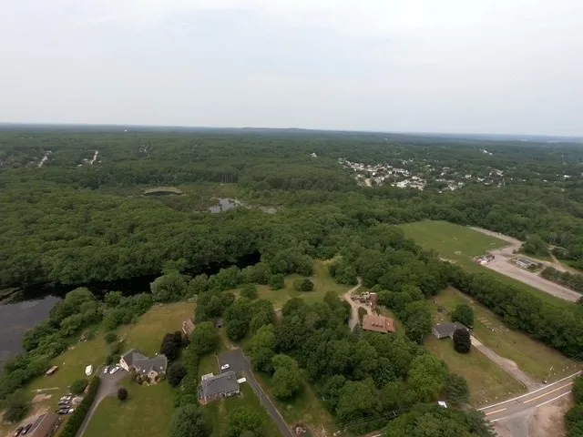 an aerial view of residential houses with outdoor space and trees