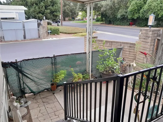 a view of a patio with a table chairs and a floor to ceiling window