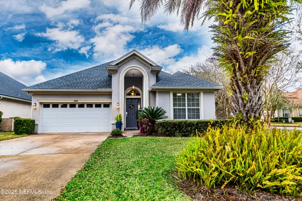 a front view of a house with a garden and plants