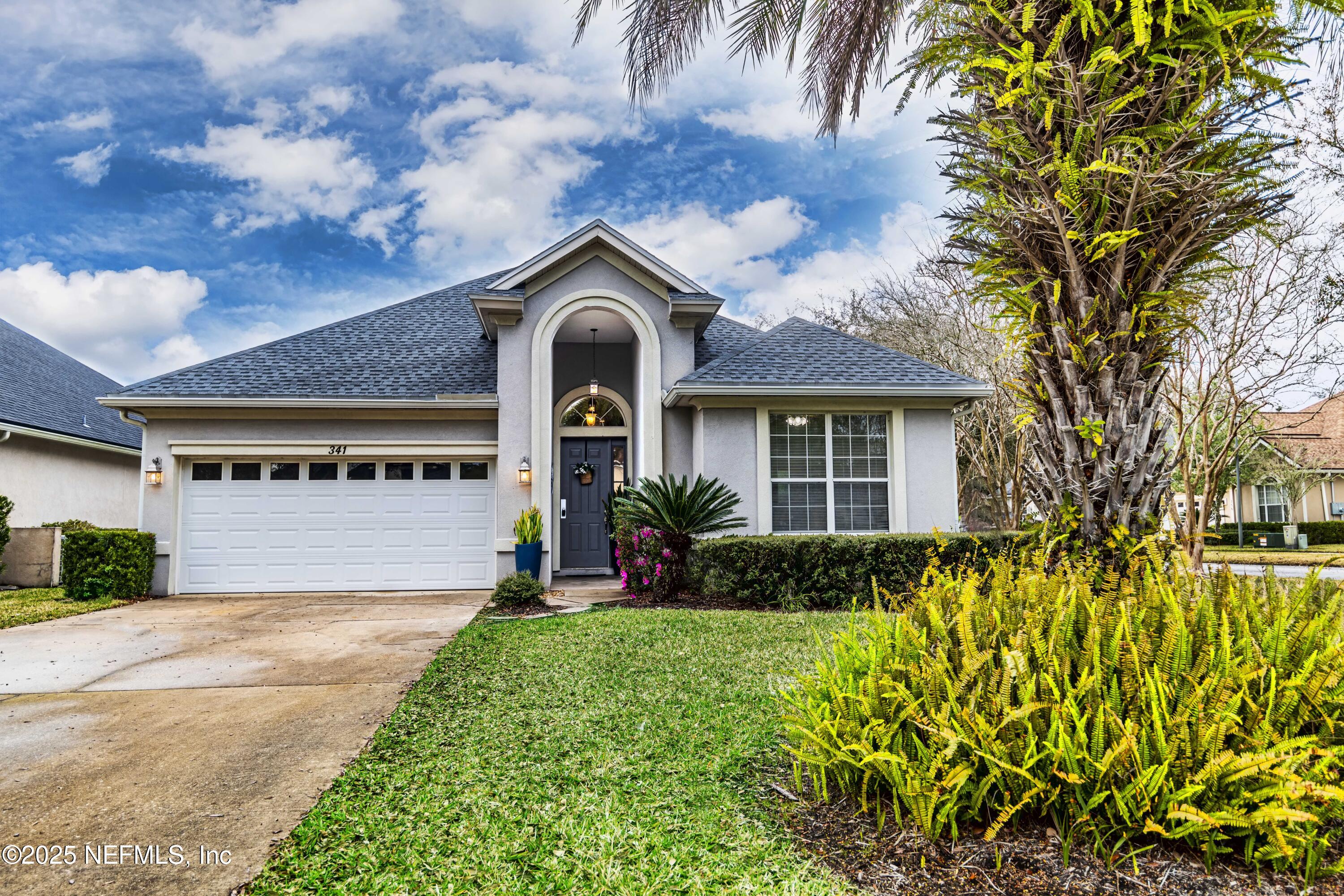 a front view of a house with a garden and plants