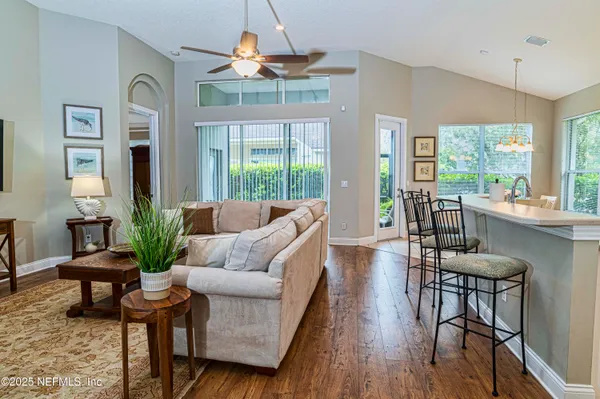 a living room with furniture dining area and a chandelier