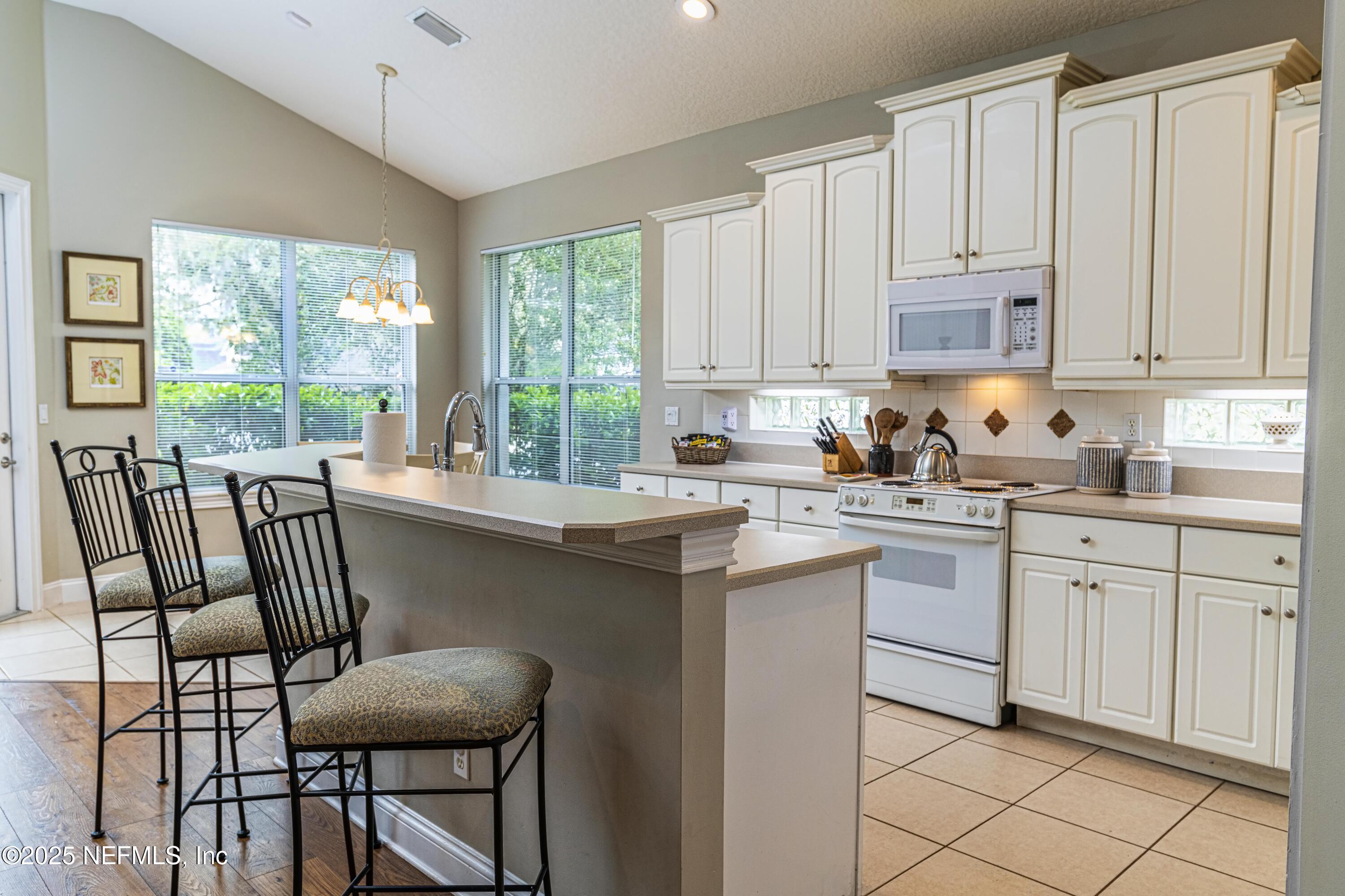 341 Island Green Drive St. Augustine, FL 32092 - Photo 17 of 49 a kitchen with a stove a sink and white cabinets