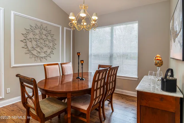 a view of a dining room with furniture and chandelier