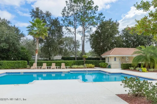 a view of house with swimming pool and yard