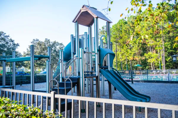 a view of a house with a small yard and wooden fence
