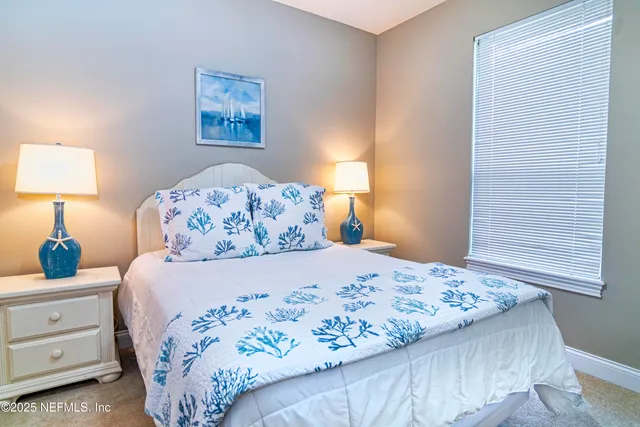 a bedroom with a bed and a lamp on dresser