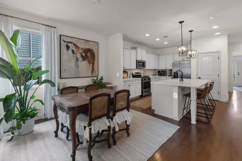 a dining room with furniture potted plants and wooden floor