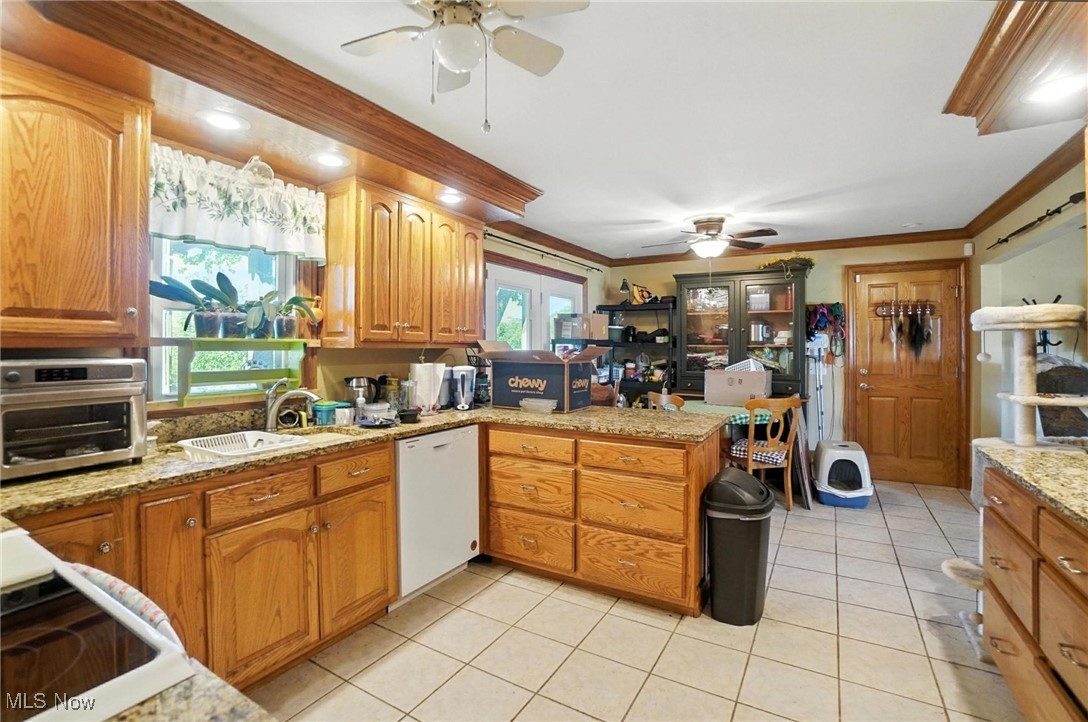 2045 Dutch Hollow Road Lima, OH 45807 - Photo 11 of 33 Kitchen featuring ceiling fan, a peninsula, light tile patterned floors, crown molding, and white dishwasher