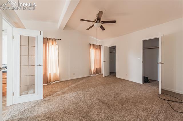 22885 Handle Road Calhan, CO 80808 - Photo 10 of 38 Unfurnished bedroom featuring carpet, ceiling fan, and multiple closets