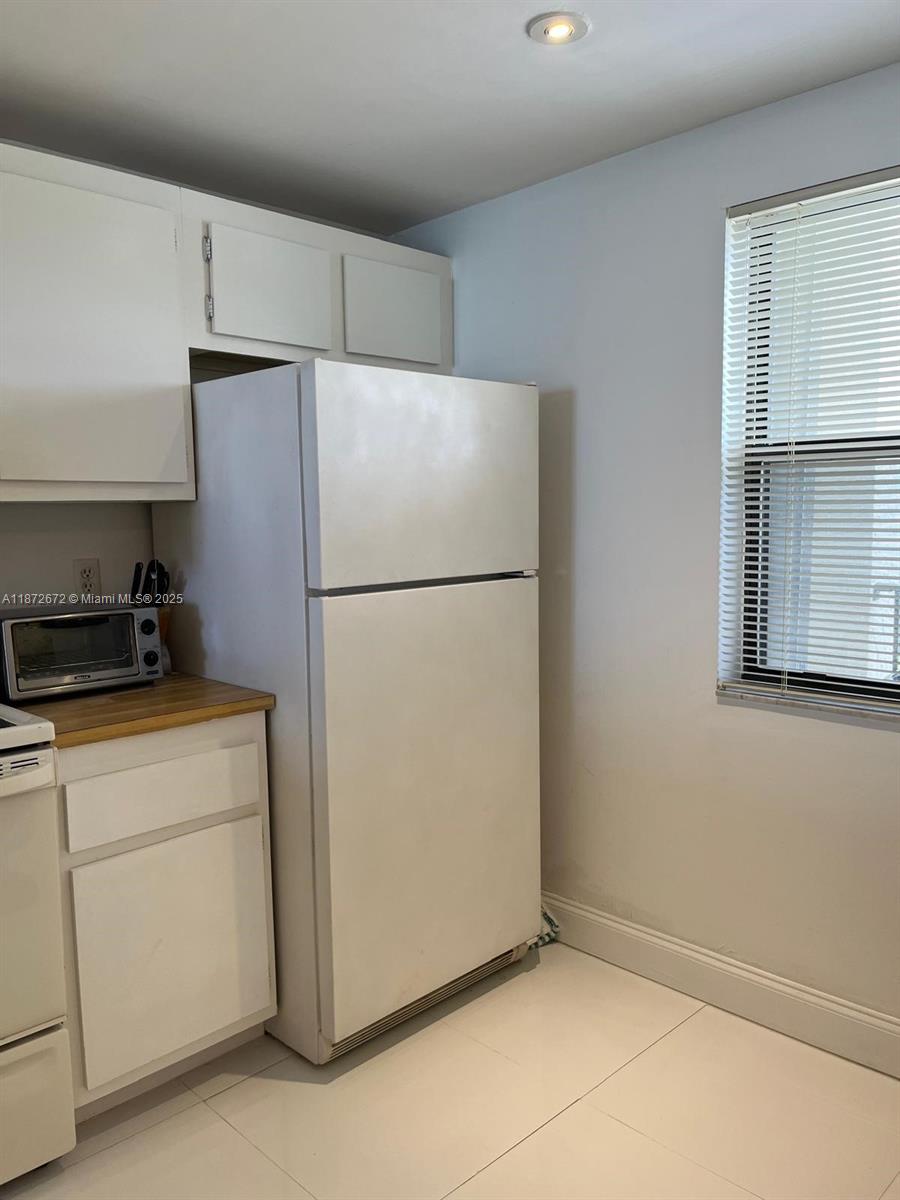 4200 North Hwy A1A, Unit 614 Fort Pierce, FL 34949 - Photo 18 of 63 a white refrigerator freezer and a stove sitting inside of a kitchen