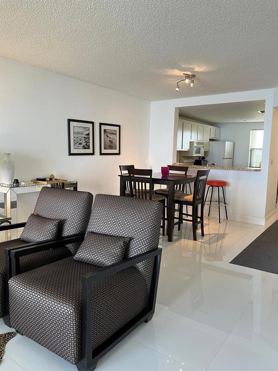 4200 North Hwy A1A, Unit 614 Fort Pierce, FL 34949 - Photo 4 of 63 a living room with furniture and a dining table with wooden floor
