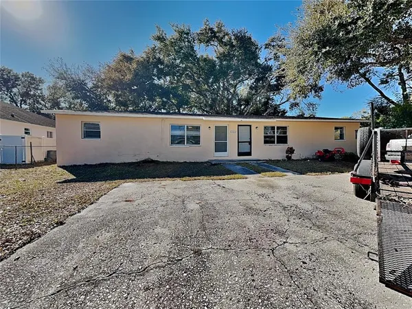 a view of a house with backyard and trees