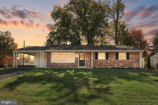 a front view of a house with a yard and trees