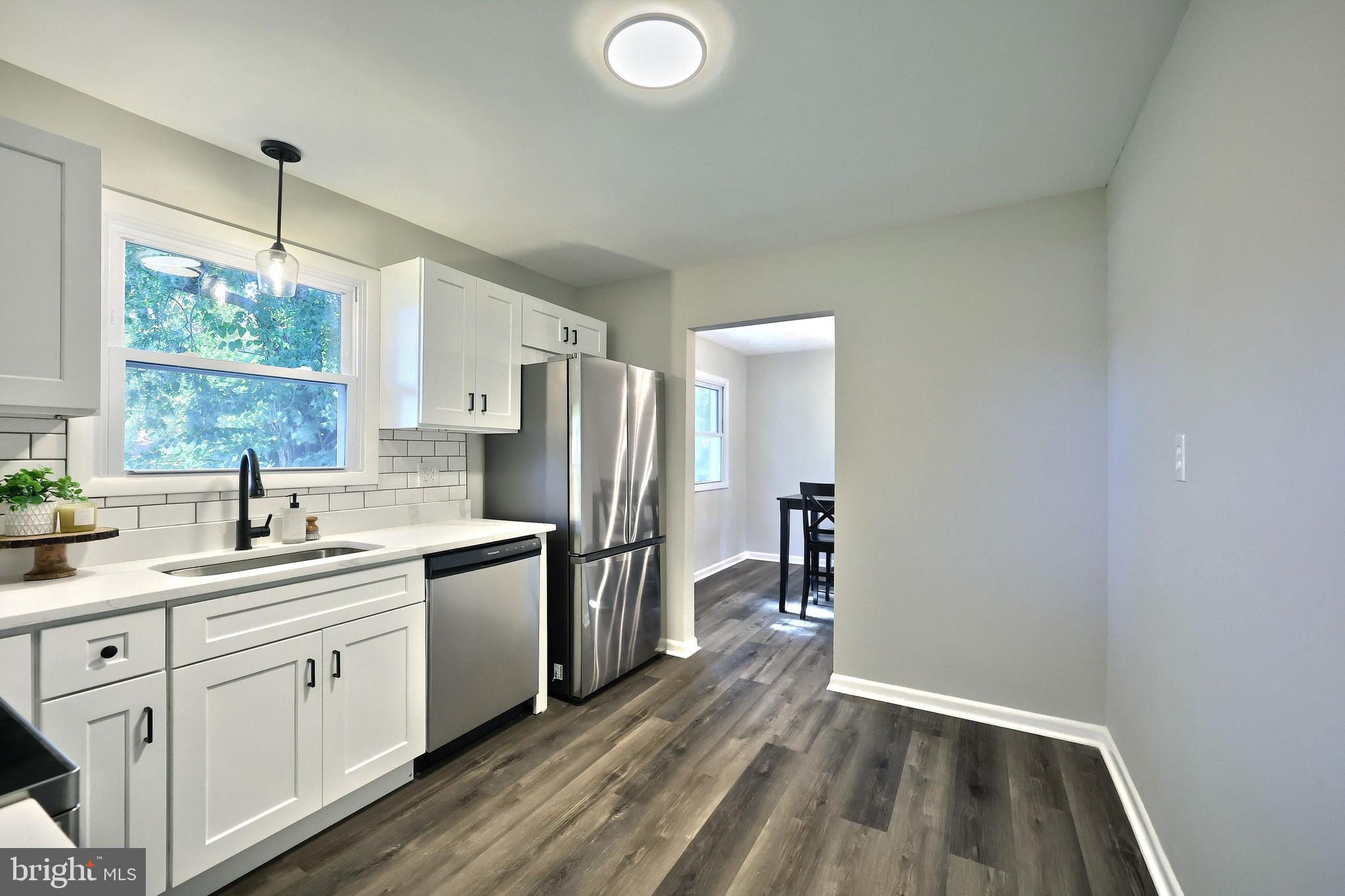 200 West Main Street Shiremanstown, PA 17011 - Photo 22 of 41 a kitchen with a sink dishwasher a stove and white cabinets with wooden floor