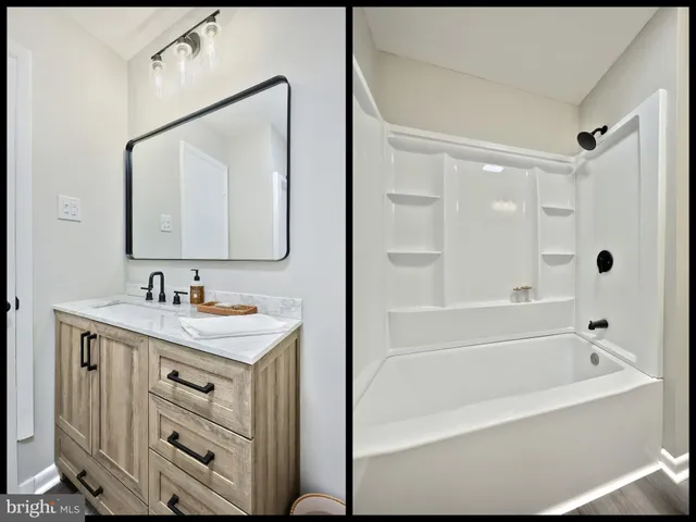 a bathroom with a bathtub a mirror a sink and vanity