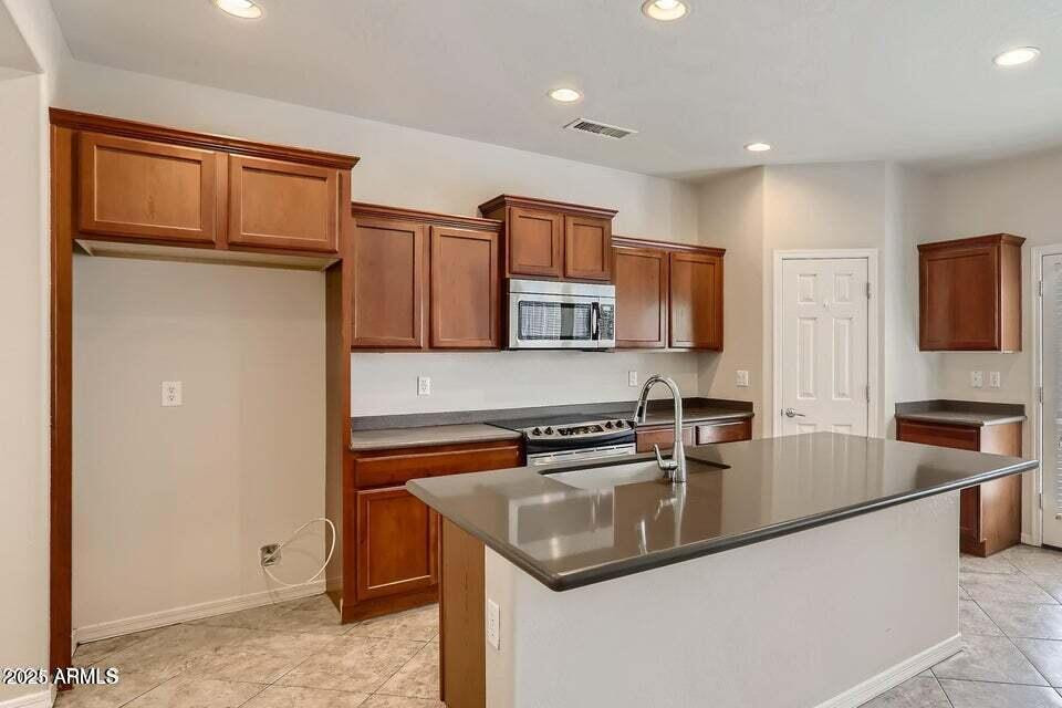 2039 West Kathleen Road Phoenix, AZ 85023 - Photo 9 of 33 a kitchen with stainless steel appliances granite countertop a sink a stove and a refrigerator with wooden floor