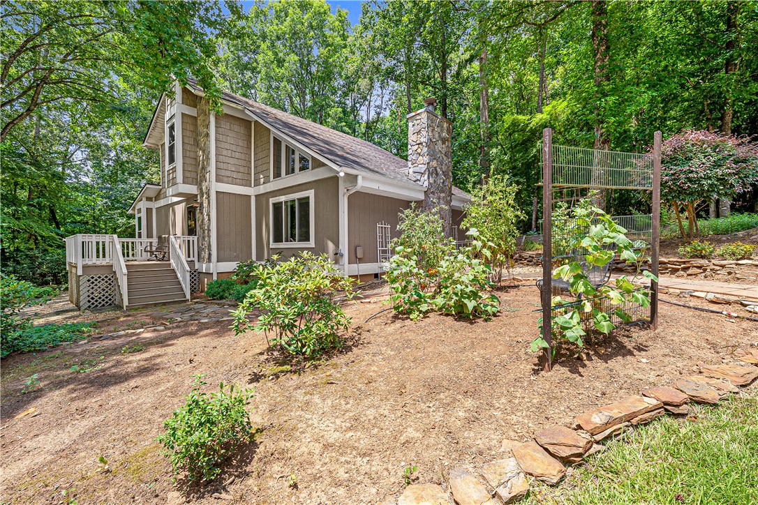 139 Tulip Lane Westminster, SC 29693 - Photo 22 of 37 A secluded sylvan retreat, this dwelling showcases a stone chimney and inviting rear deck for outdoor enjoyment.