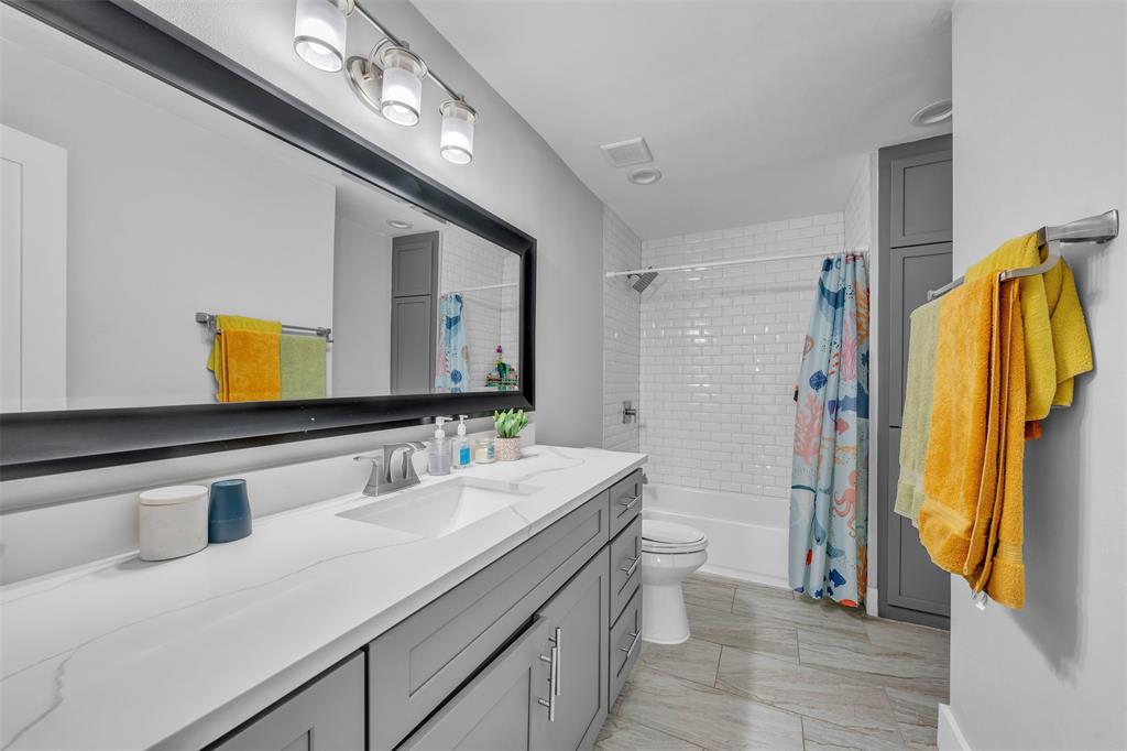 3837 Kimball Ridge Drive Dallas, TX 75233 - Photo 13 of 40 a bathroom with a sink a toilet and a large mirror