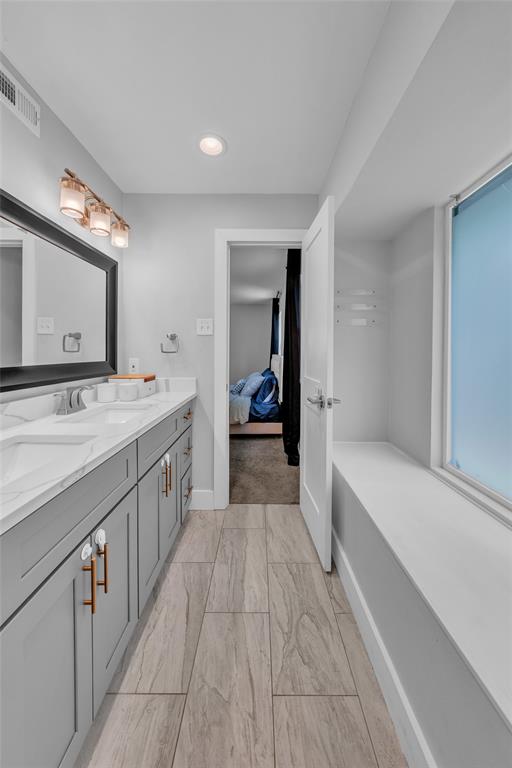 3837 Kimball Ridge Drive Dallas, TX 75233 - Photo 30 of 40 a bathroom with a double vanity sink a mirror and a bathtub