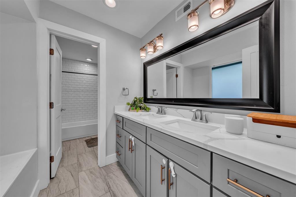 3837 Kimball Ridge Drive Dallas, TX 75233 - Photo 32 of 40 a bathroom with a double vanity sink a mirror and a bathtub
