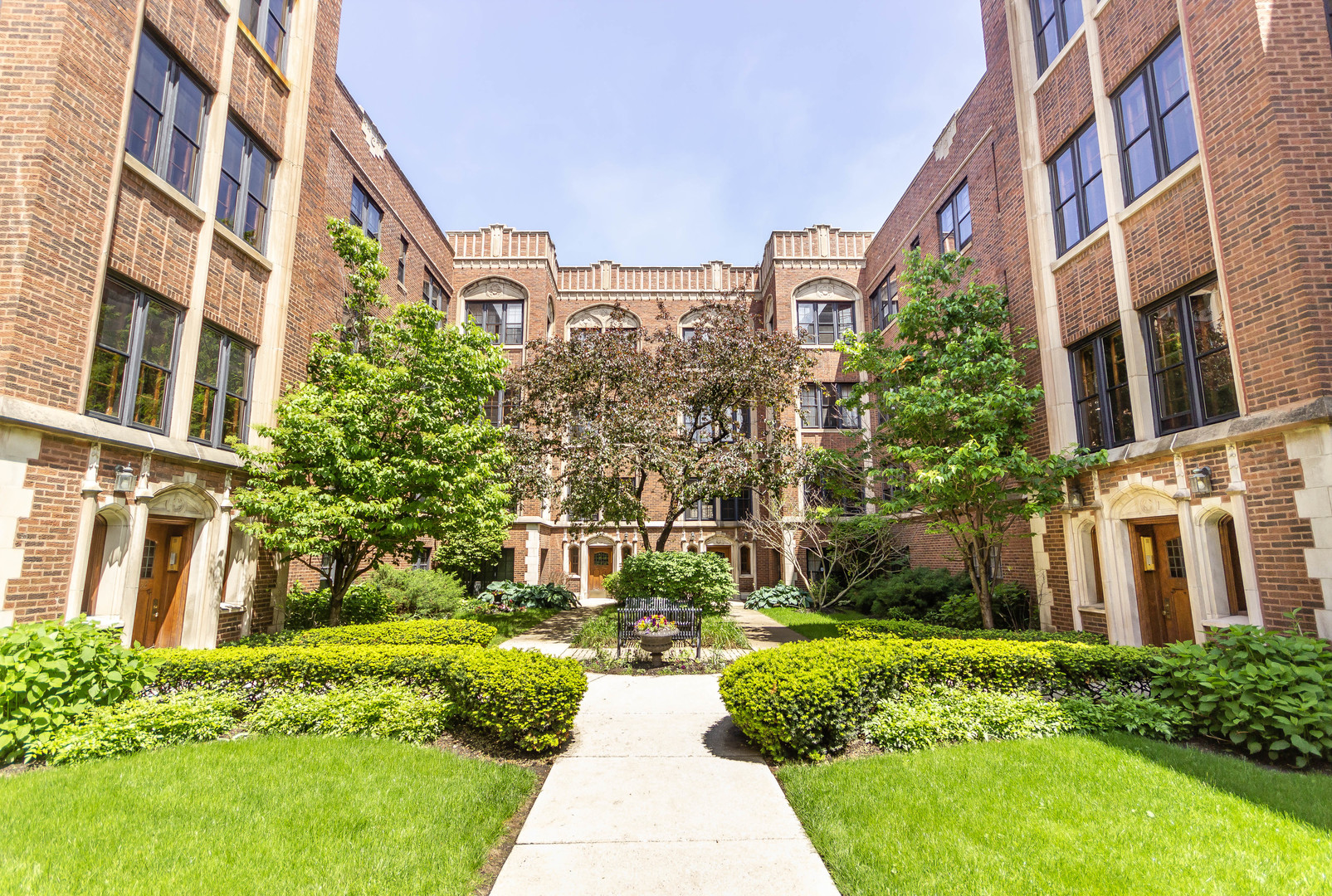 1360 East Madison Park, Unit B Chicago, IL 60615 - Photo 7 of 19 a front view of a multi story residential apartment building with yard and bench