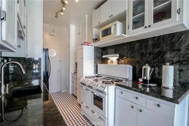 a kitchen with stainless steel appliances granite countertop a stove and cabinets