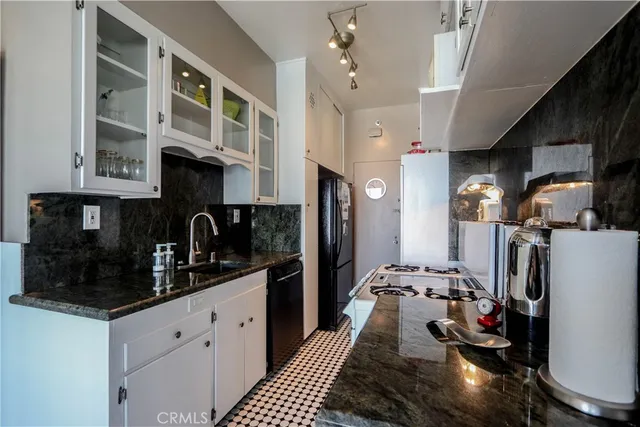 a kitchen with stainless steel appliances granite countertop a stove a sink a refrigerator and cabinets