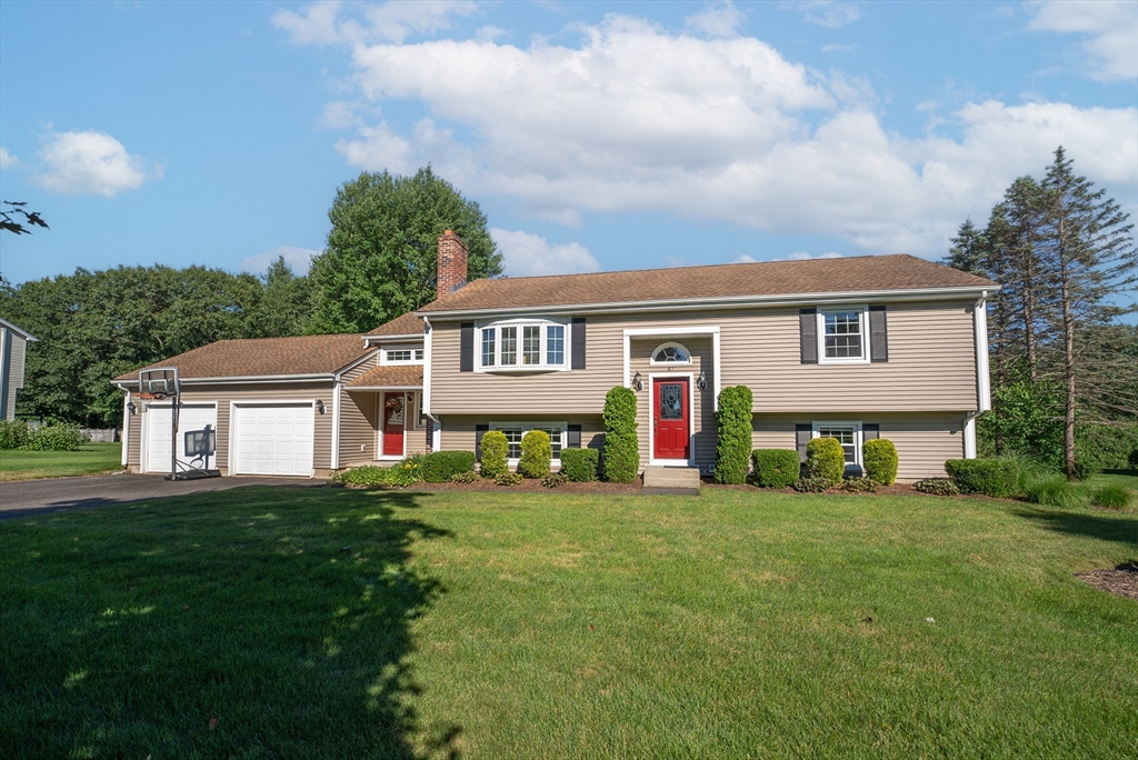 a view of a house with a big yard and large trees