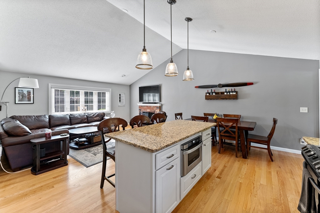 47 Deer Run Road West Springfield, MA 01089 - Photo 9 of 41 a open kitchen with stainless steel appliances granite countertop a stove top oven a dining table and chairs with wooden floor