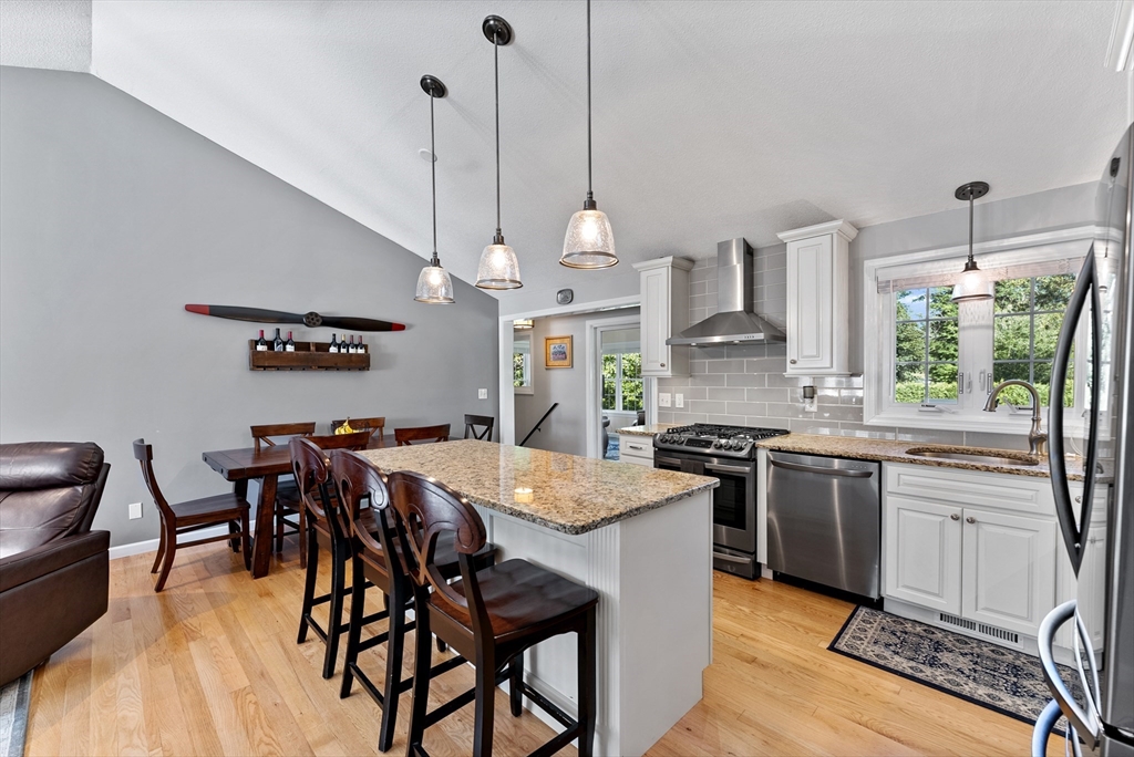 47 Deer Run Road West Springfield, MA 01089 - Photo 10 of 41 a kitchen with stainless steel appliances granite countertop a stove top oven a sink a dining table and chairs with wooden floor