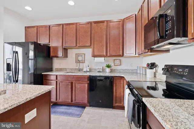 a kitchen with stainless steel appliances granite countertop a stove a sink dishwasher a refrigerator and cabinets with wooden floor