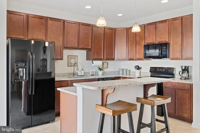 a kitchen with kitchen island granite countertop wooden cabinets and stainless steel appliances