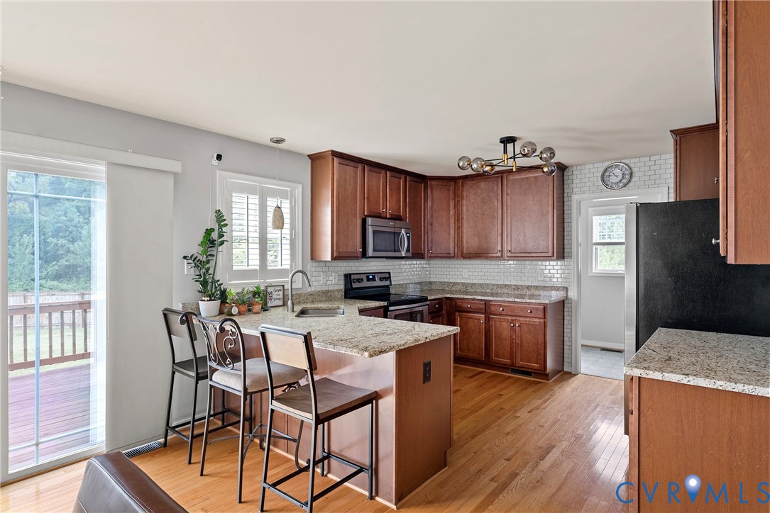 11223 Hill Ridge Court Ashland, VA 23005 - Photo 11 of 35 a kitchen with granite countertop wooden floors and wooden cabinets