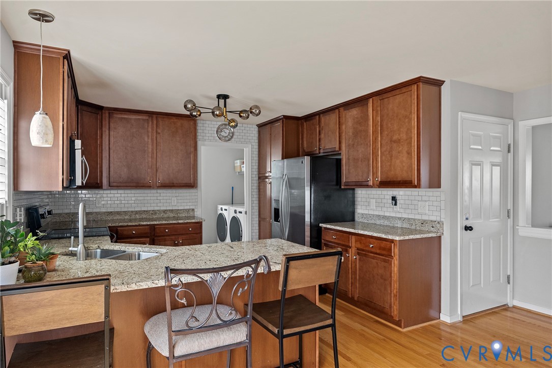 11223 Hill Ridge Court Ashland, VA 23005 - Photo 13 of 35 a kitchen with a refrigerator a stove a sink and chairs