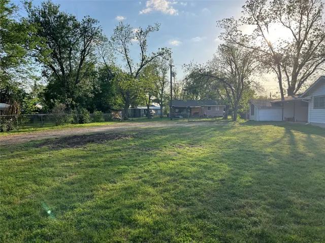 a view of a field with trees in the background