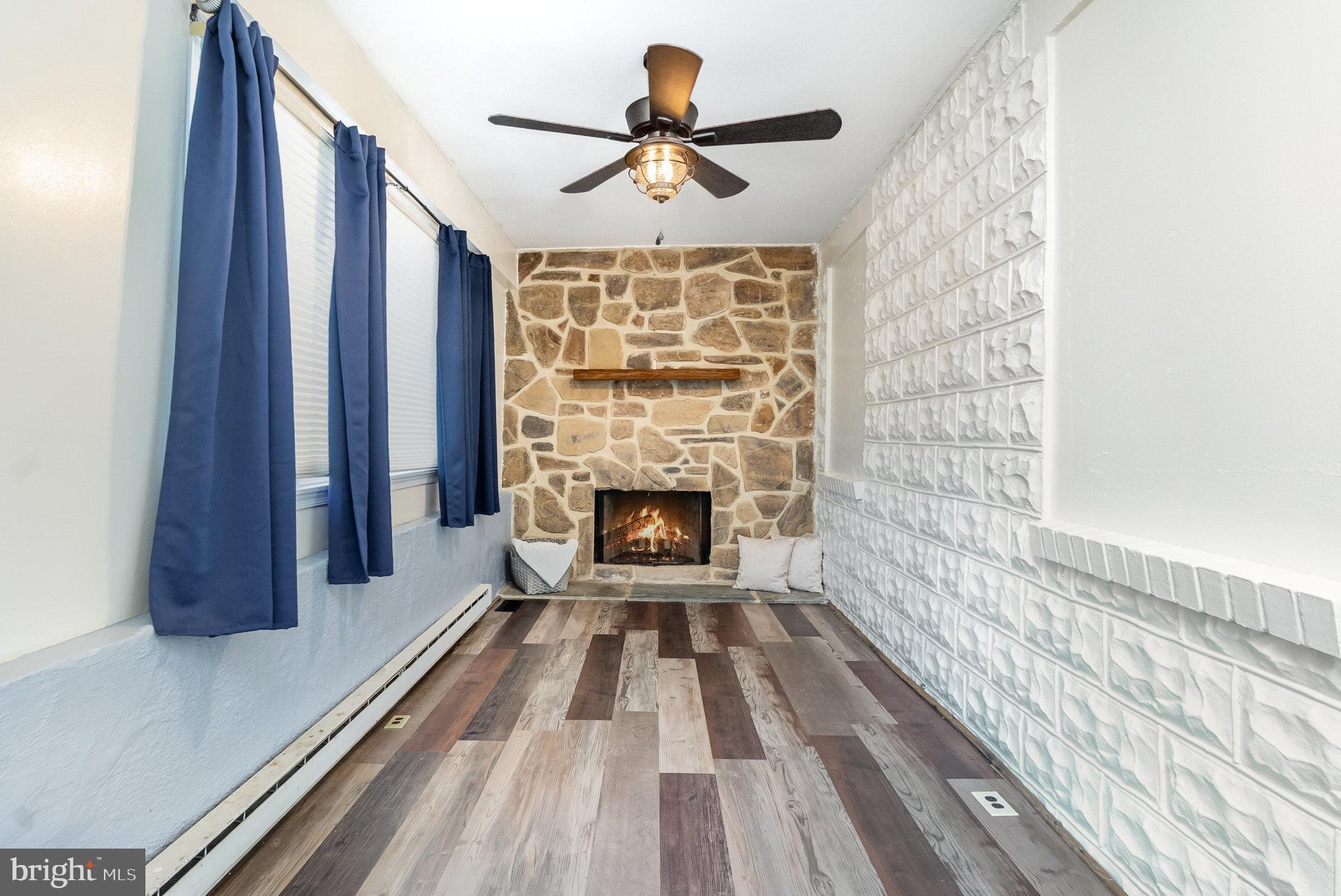 7401 Greenbank Road Baltimore, MD 21220 - Photo 5 of 58 a view of a livingroom with wooden floor a fireplace and window