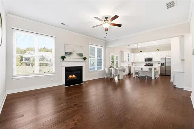 a view of a livingroom with furniture a fireplace wooden floor and chandelier
