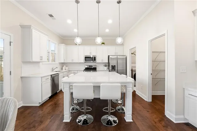 a kitchen with a table chairs refrigerator and microwave