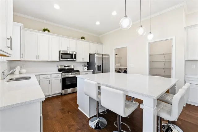 a kitchen with kitchen island a stove a table and chairs in it