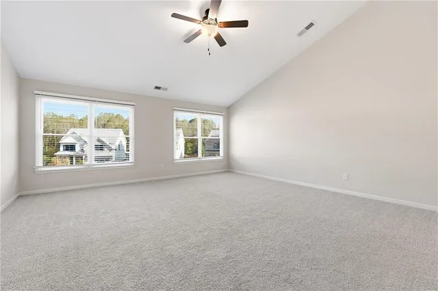 an empty room with windows and ceiling fan